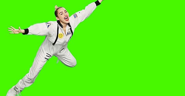 Miley Cyrus floats on a green screen