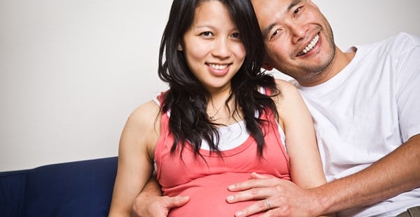 Expectant parents smiling because they saved money on maternity clothes