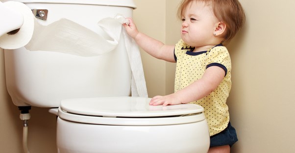 A little girl investigating the toilet.