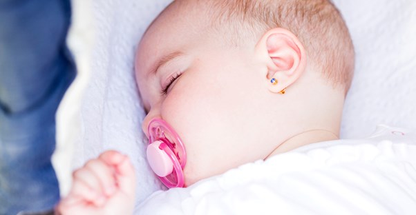 A baby with a cleft palate sucking on a pacifier