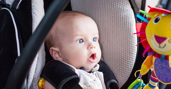 A baby riding in a safe and affordable car seat