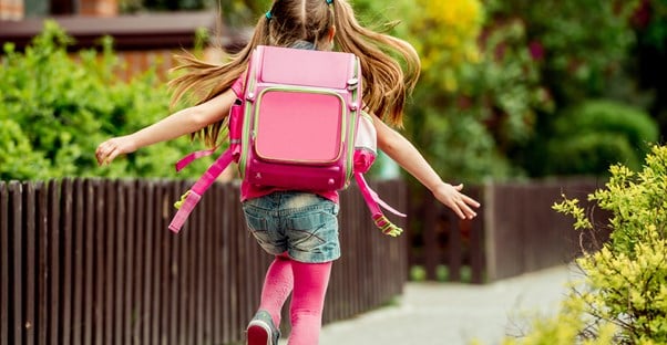 Young girl excitedly going to school