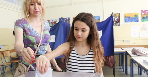 Teacher helping student vote at school