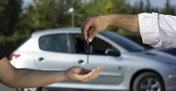 Car dealer handing over the keys to a new car purchased through financing