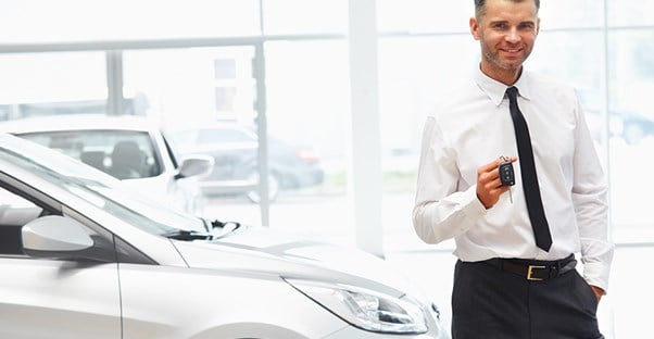 guy holding car keys to new car after getting an auto loan
