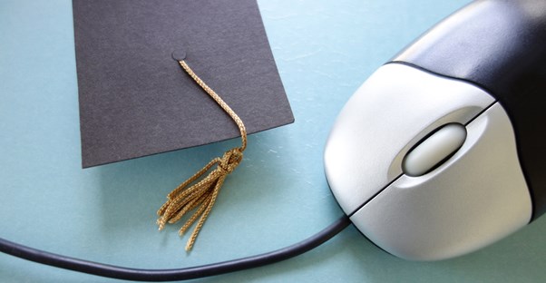 Graduation cap sitting next to a computer mouse after you obtain an electrical engineering degree