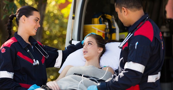 EMTs comfort a young girl on a stretcher