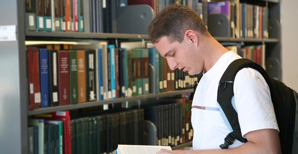 A student reads a book in the school library