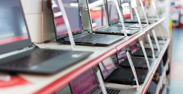 An array of computers on a store display shelf.