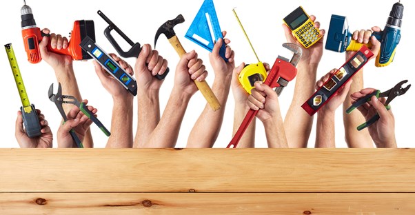 Hands holding tools for DIY home remodeling