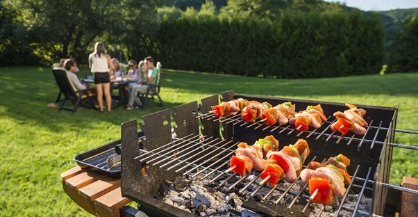 a family enjoys grilling in their backyar