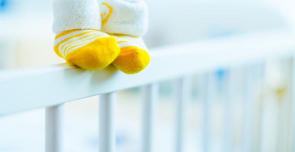 a close up of baby feet perched on a crib