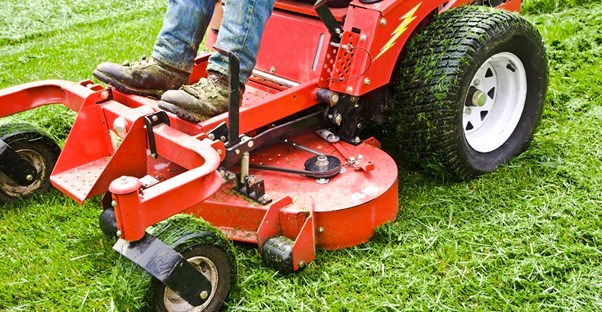 a riding lawn mower goes over the grass