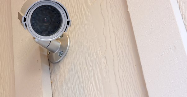 a home security system camera stares directly at the viewer