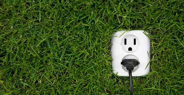 A power plug in the grass to represent energy efficiency