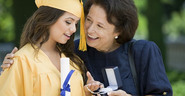 A high school graduate opening a present from her grandmother.