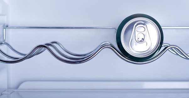 A can of soda sitting inside a mini fridge.