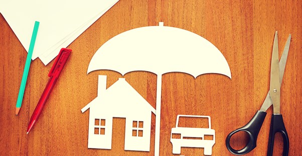 Umbrella over a car and home representing umbrella insurance