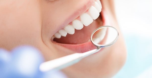 Un dentista examina los dientes de una mujer.