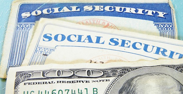 Social Security cards sitting with a 100 dollar bill