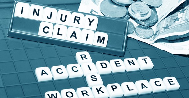 Scrabble pieces spelling out injury claim, accident, risk, and workplace
