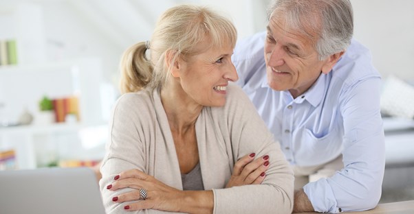 An elderly couple smiles at each other because they have reach the eligible age for social security benefits.