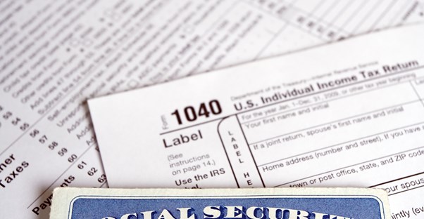 A social security card laying on top of financial documents containing income information.