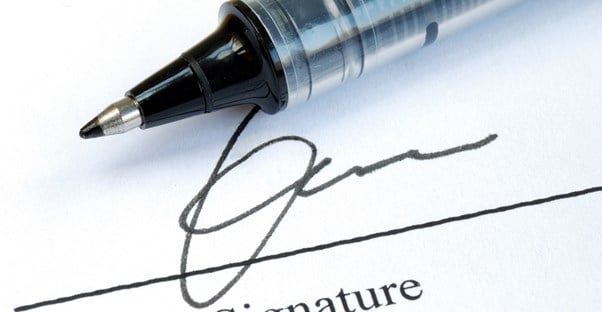 Pen and signature on a title insurance policy and mortgage