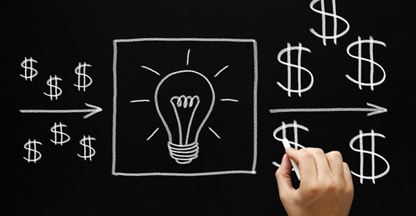 An image drawn on a chalkboard of dollar signs pointing toward a lightbulb representing an idea and an arrow pointing from the lightbulb to more dollar signs
