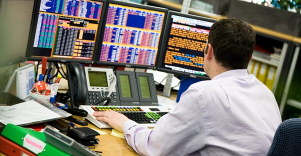 A stock analyst sits at his desk