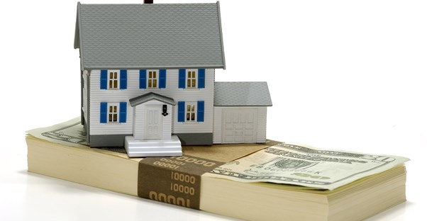 Home representing a residential REIT on top of a stack of dollar bills