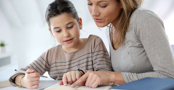 A mother helps her daughter with schoolwork