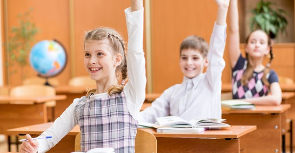 Students raise their hands during class