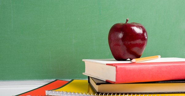 An apple sits on top of school books