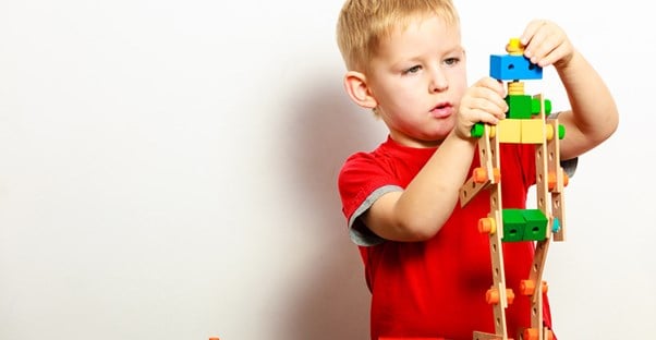 A young boy builds with blocks