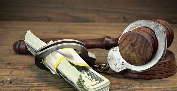 a gavel handcuffed to money to symbolize a bail bond