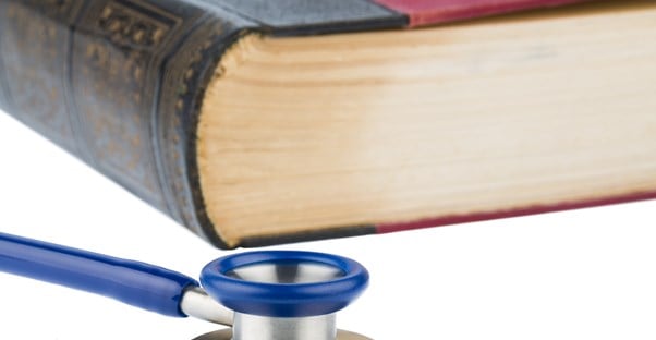 Book and stethoscope representing legal code