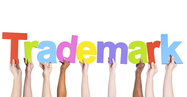 multiple individual arms holding up individual letters spelling out the word trademark