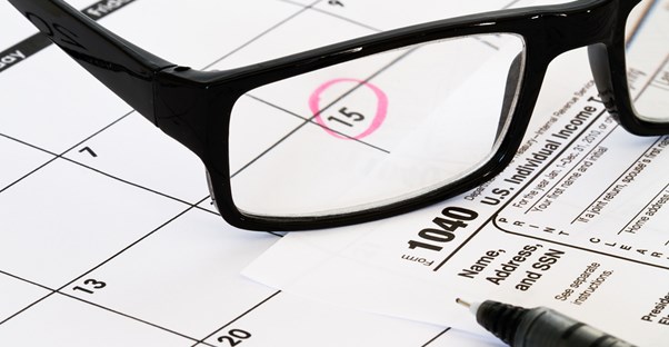 Glasses sitting on a calendar with tax day circled