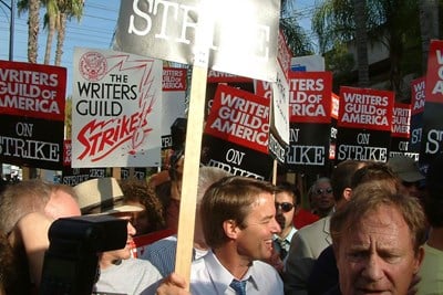 Postal worker on strike holding a sign