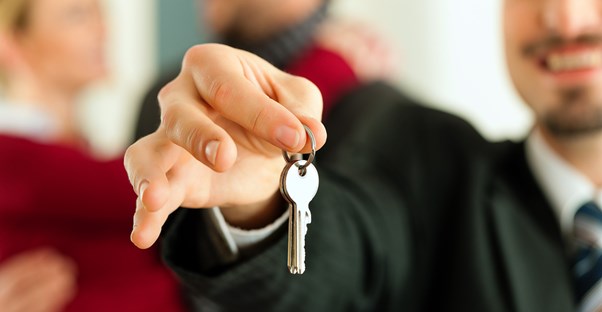 A landlord handing a new tenant the keys to their new place