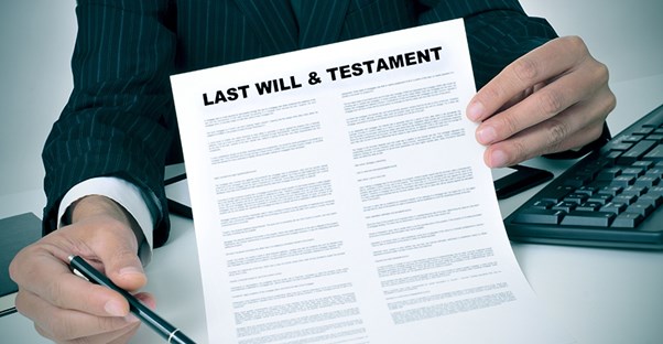 Man holding paper titled "Last Will & Testament"