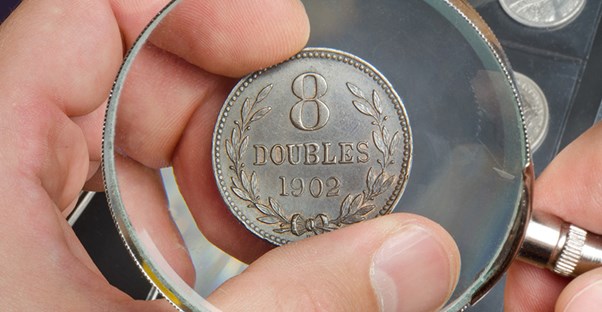 examining a rare coin under a magnifying glass