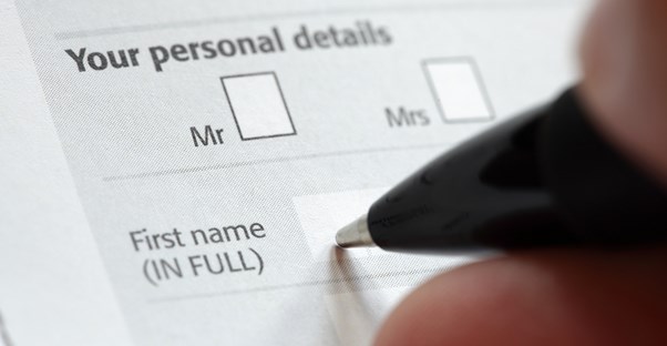 a pen filling out a form requesting personal details