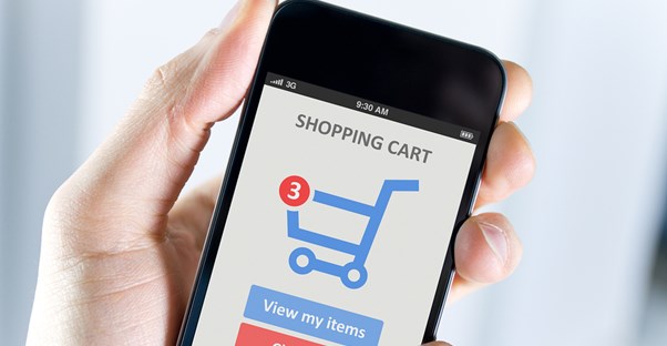 Close up of a man holding a smartphone displaying the shopping cart of an e-commerce site that uses insider tips to be successful.