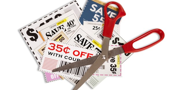 Red scissors laying on top of a stack of coupons after a woman decided clipping coupons wasn't worth it.