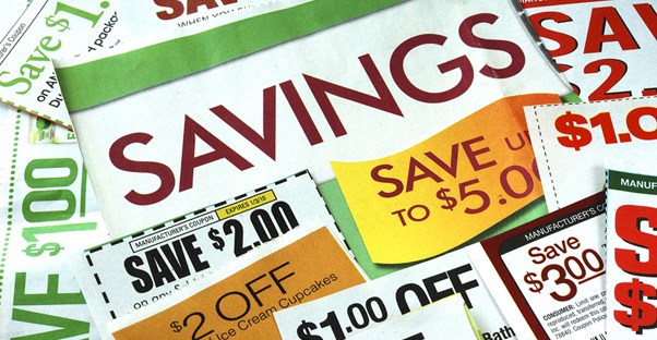 A pile of coupons with one large coupon reading Savings to represent that extreme couponing saves money.