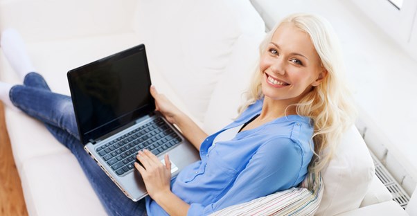 A woman smiles while using her satellite internet connection in her rural home.