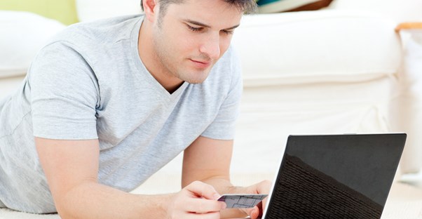 Man looking at his credit card to compare rewards