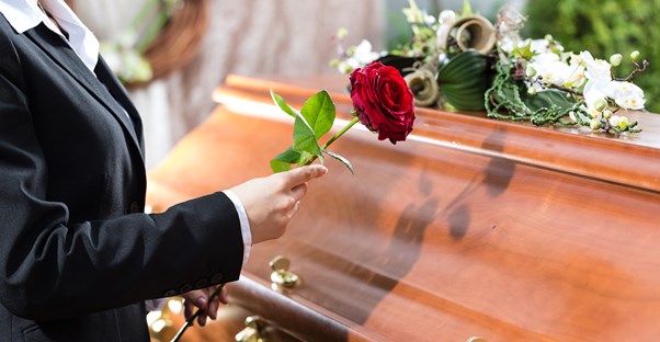 Person paying their respects to a friend at a cost-effective funeral